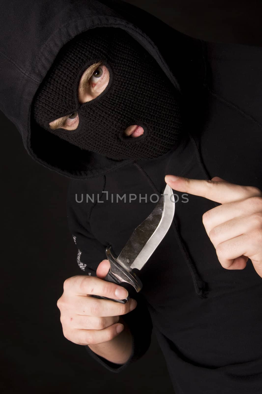 evil criminal with a knife wearing balaclava