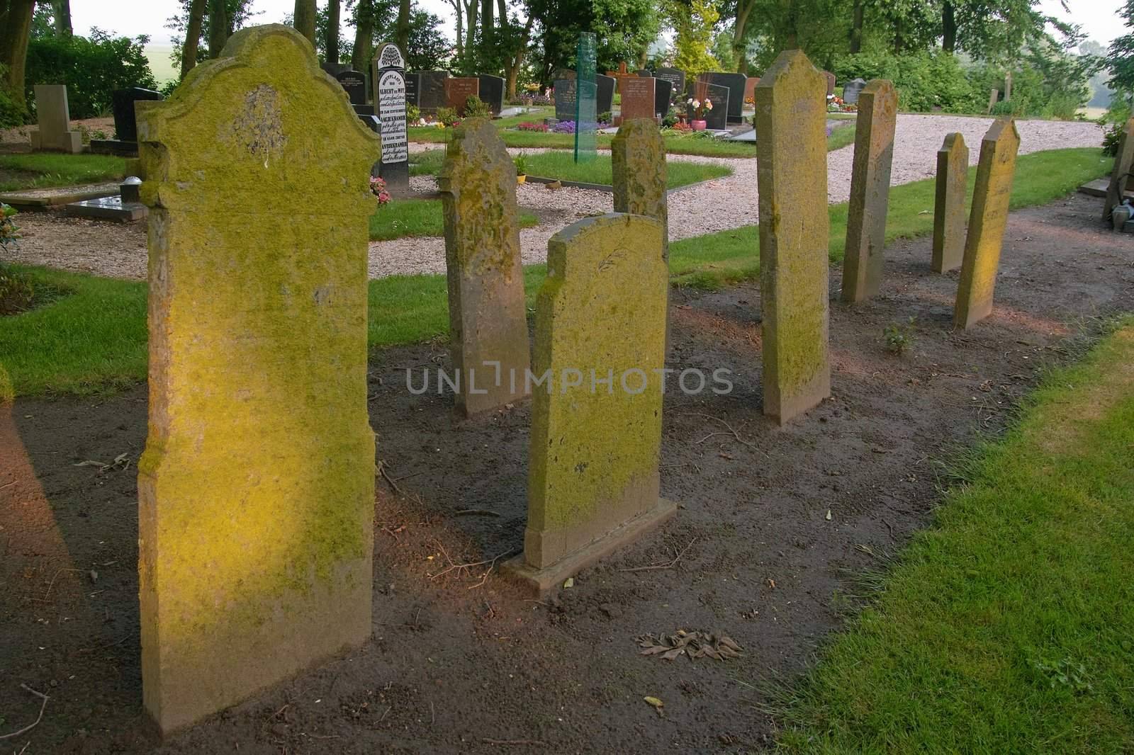 Old tombstones with wome newer ones in the background catching the rays of the setting sun while the day is drawing to an end. Another one bites the dust....