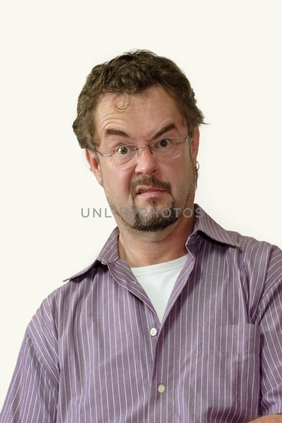 Young man grimacing on white background