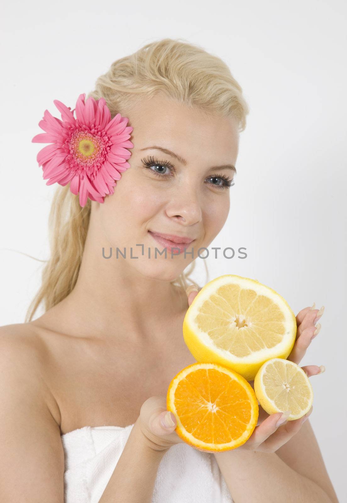 young lady with fruits and pink flower in hair on isolated studio pictures
