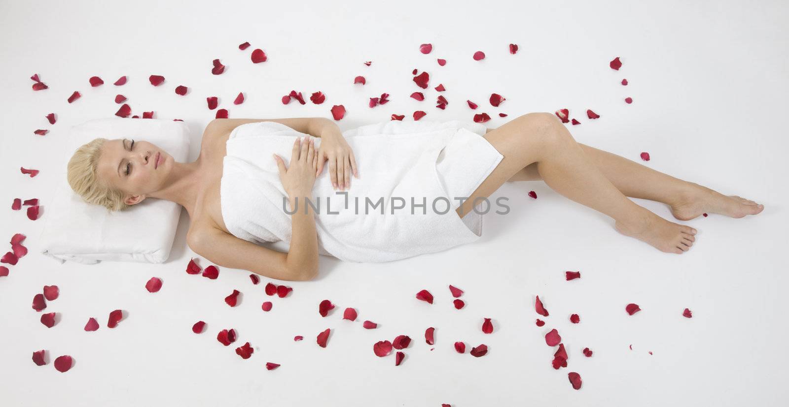 model lying with petals spread around on isolated studio pictures