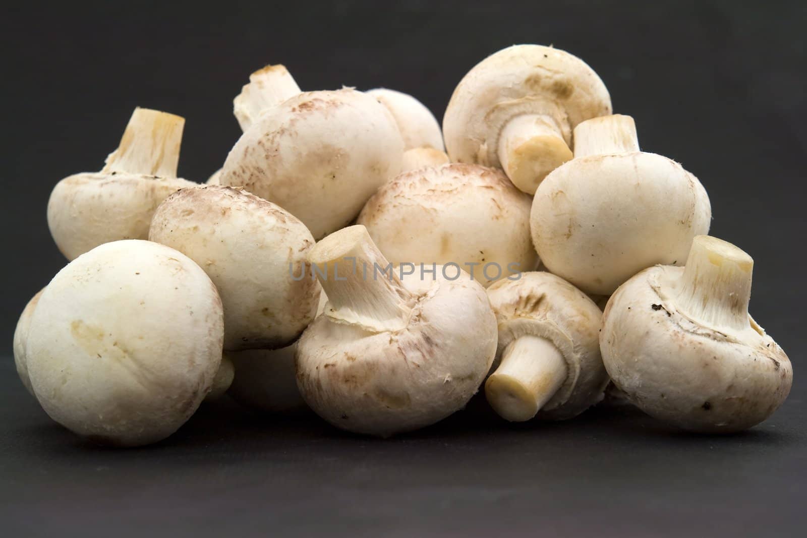 Mushrooms. Heap of champignons on a black background