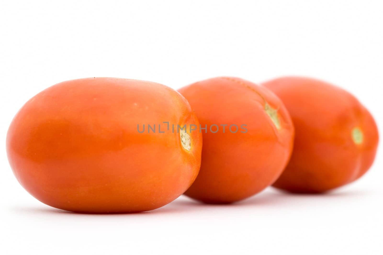 Three red tomatoes on a white background