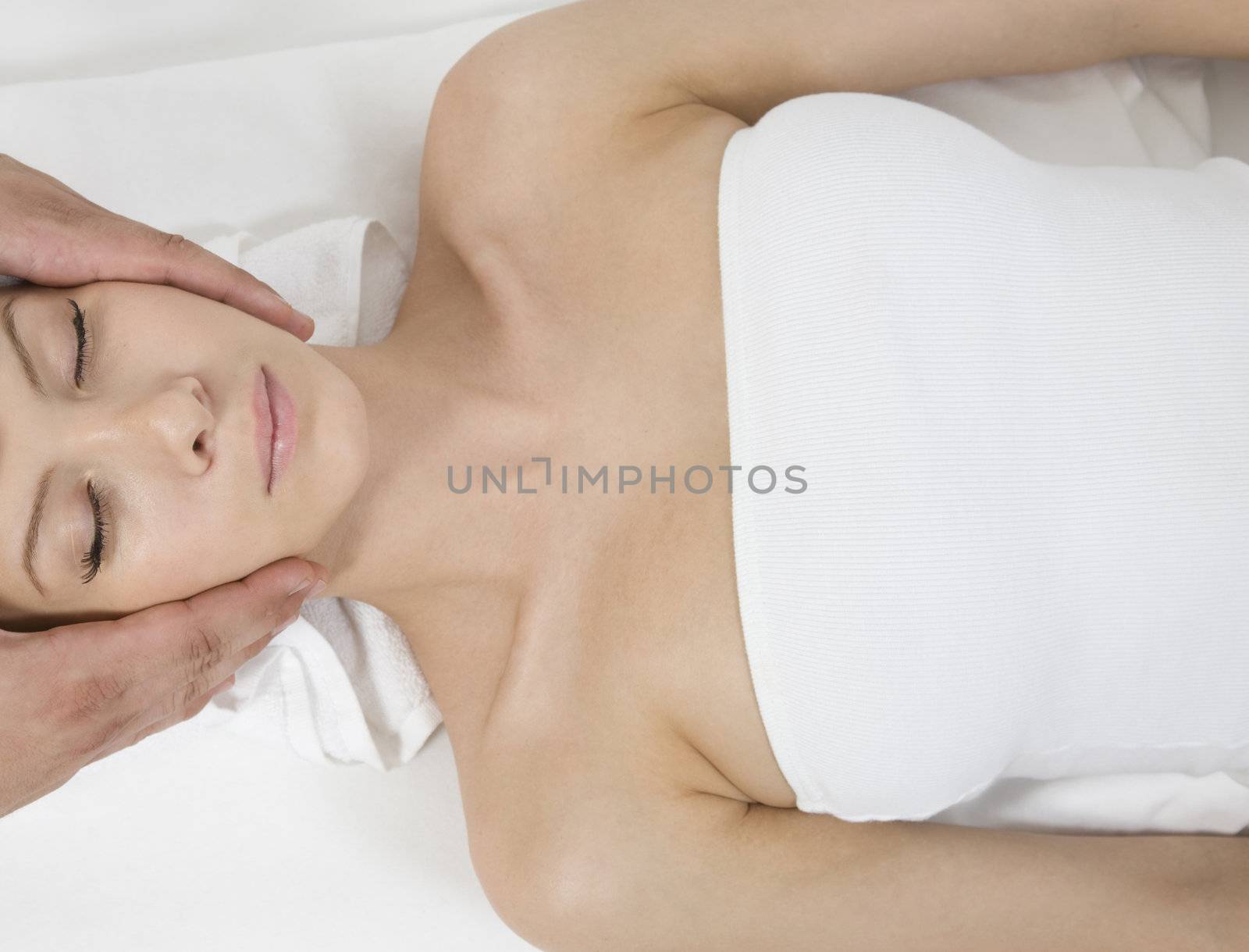 woman receiving face massage on isolated background