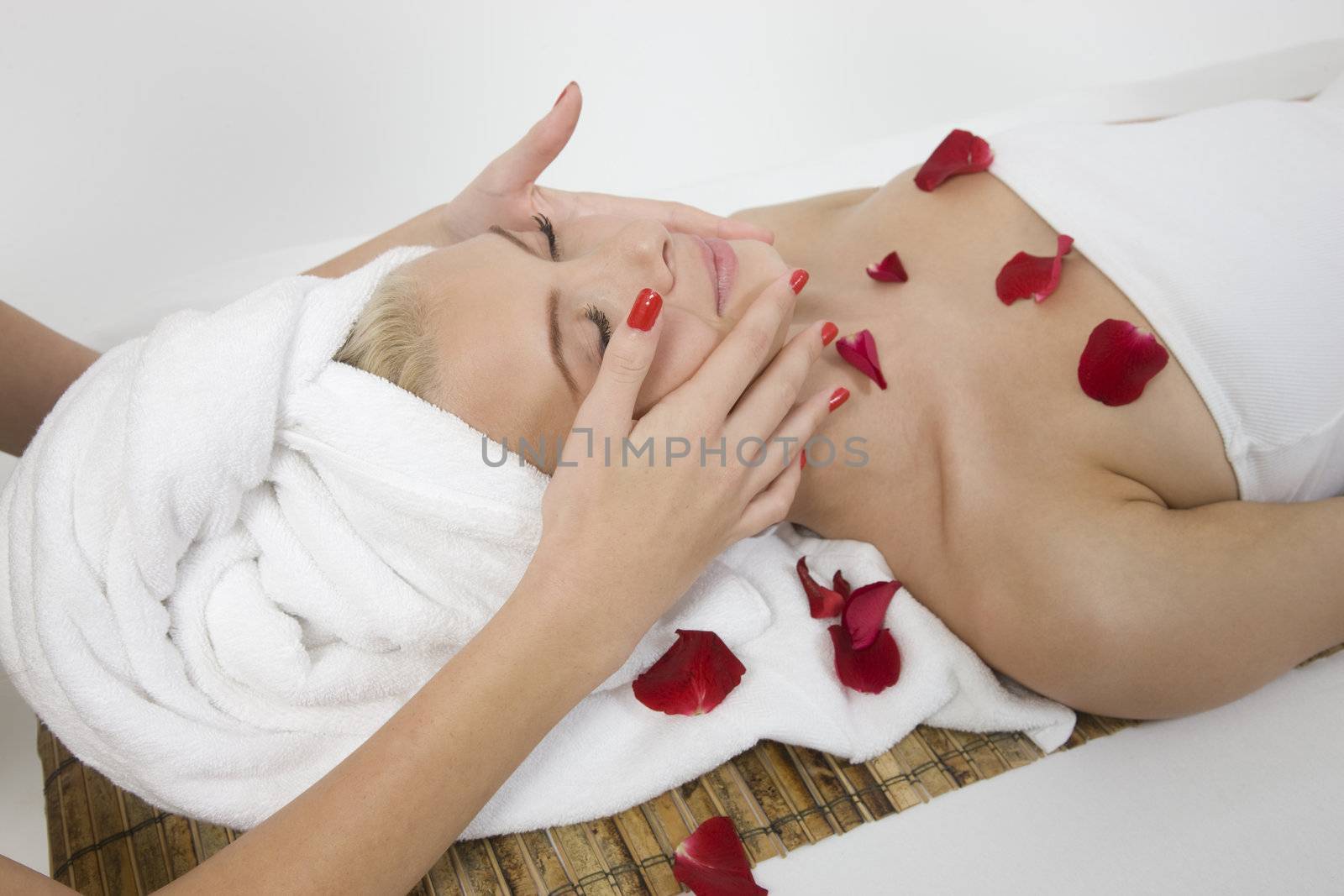 woman receiving face massage from female hands on isolated background