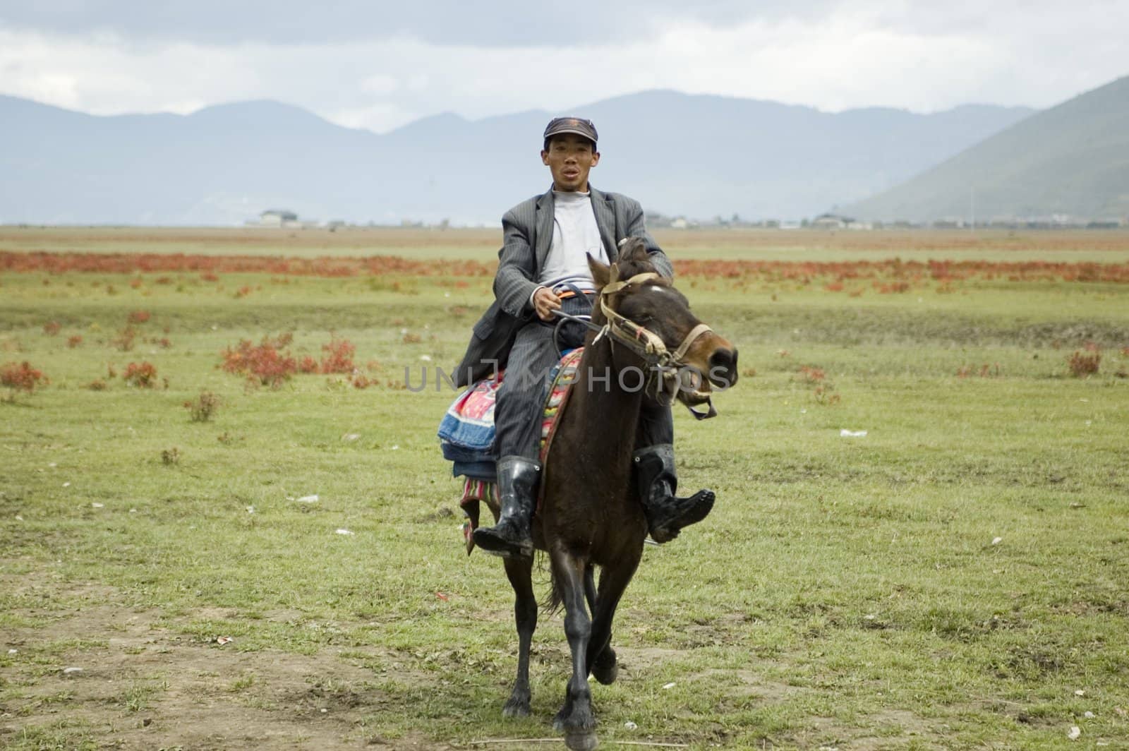 CHINA, YUNNAN PROVINCE, SHANGRILA - SEPTEMBER 13: Chinese nomad, horse rider in Shangrila area, renting horse for tourists.