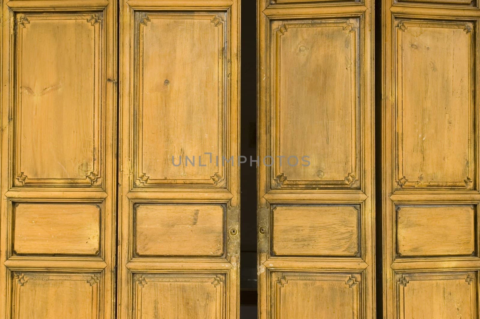 Ancient, wooden door painted in yellow color, house in Shangrila, Yunnan province, China.