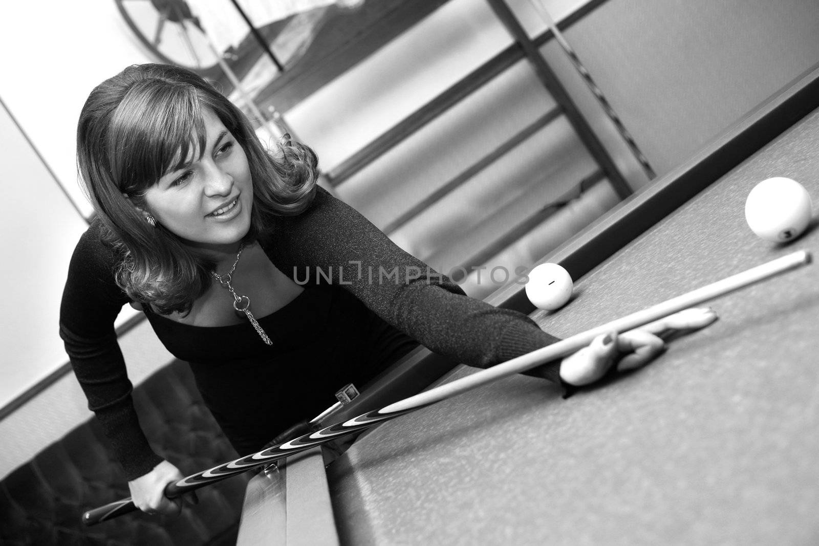 The pregnant woman plays on billiards