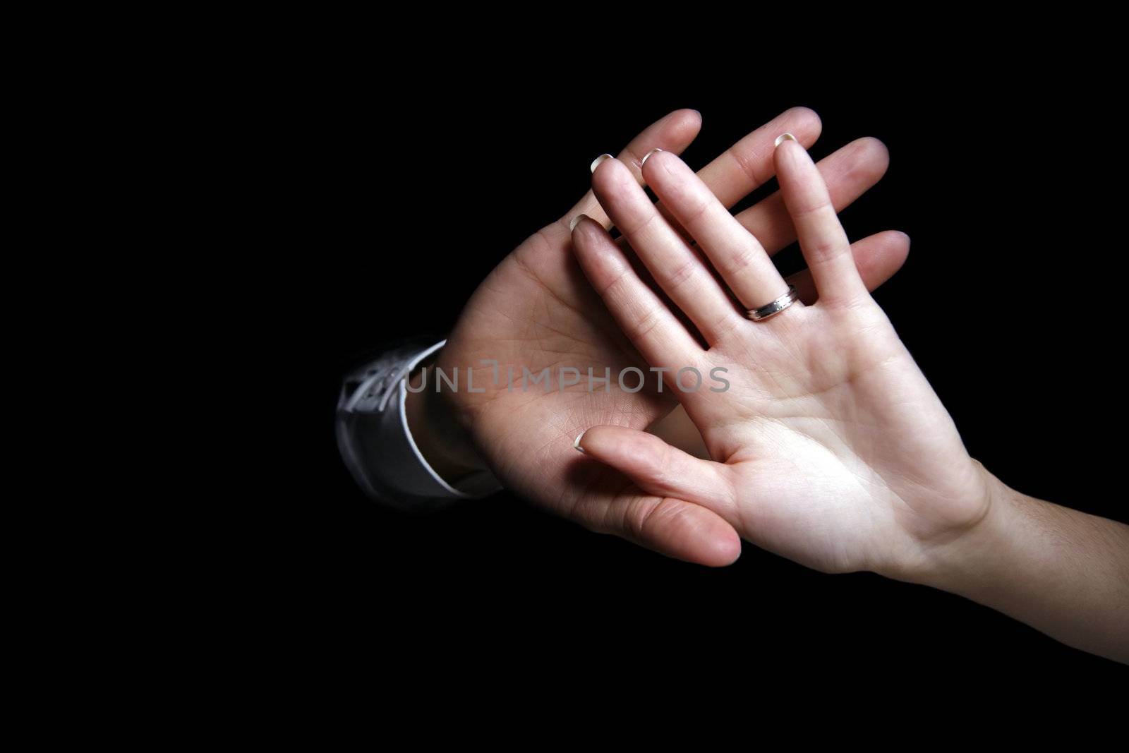 Man's and female hand on a black background