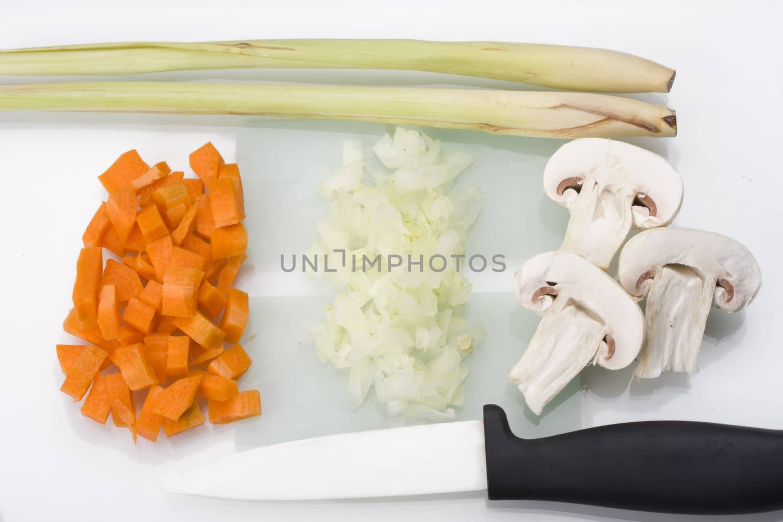 sliced carrots, onions and champignons on a glass chopping board by bernjuer