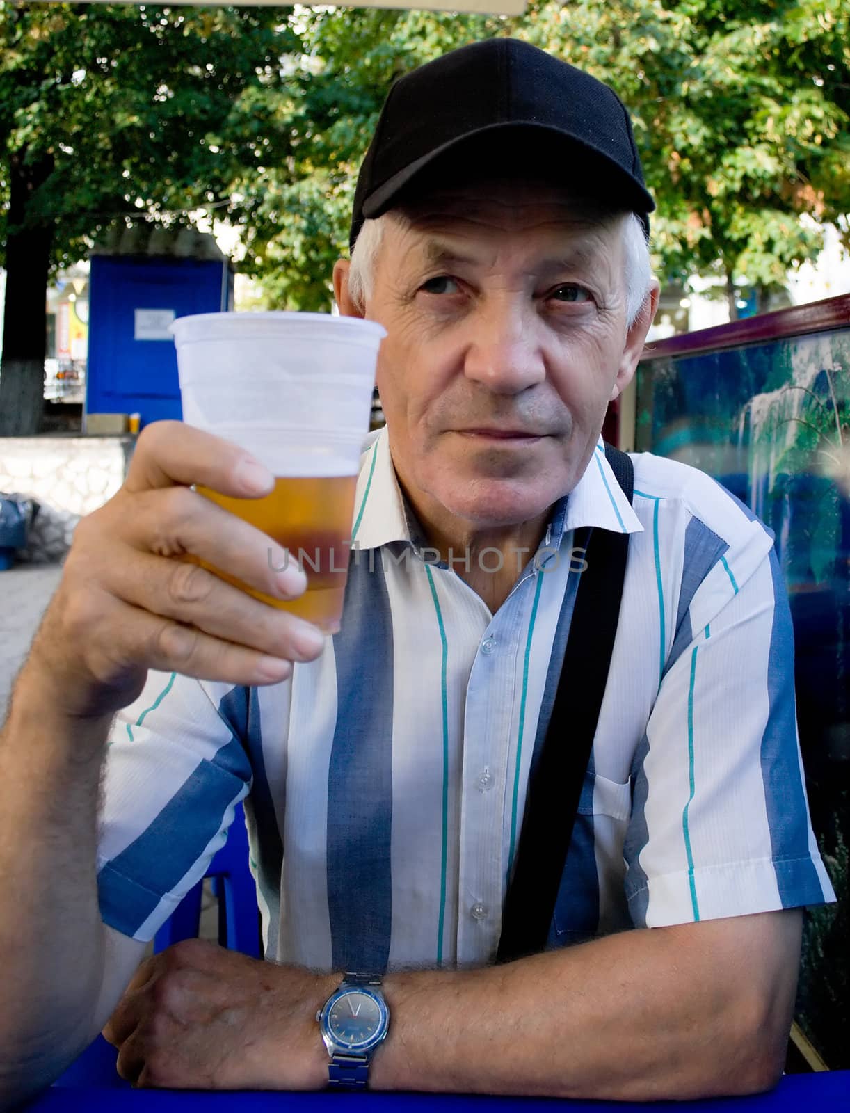 The elderly man with beer in park. A portrait