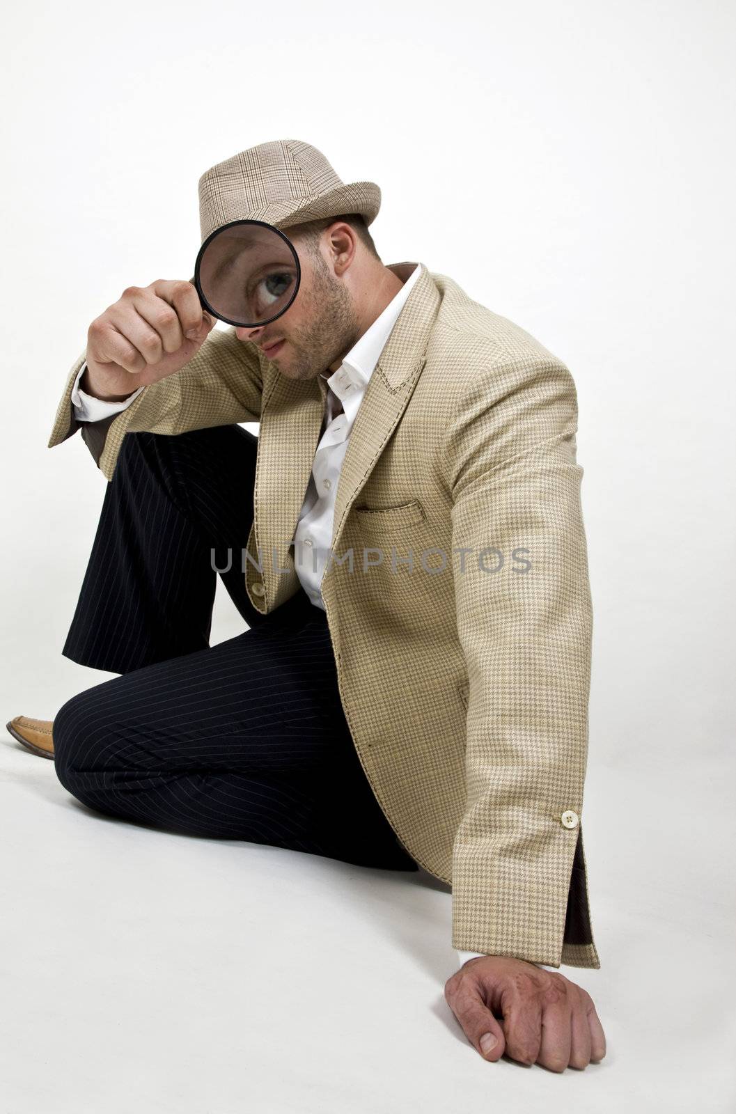 man holding magnifier close to his eye on isolated background
