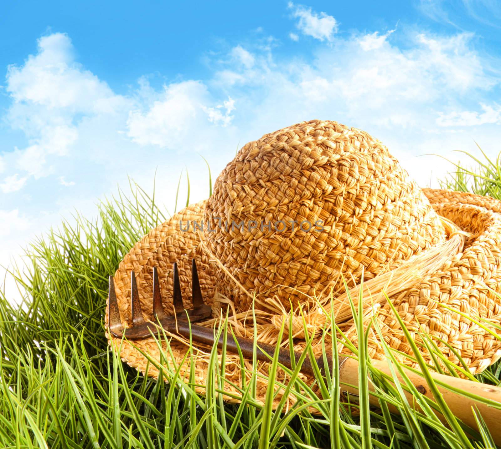 Straw hat on grass with blue sky