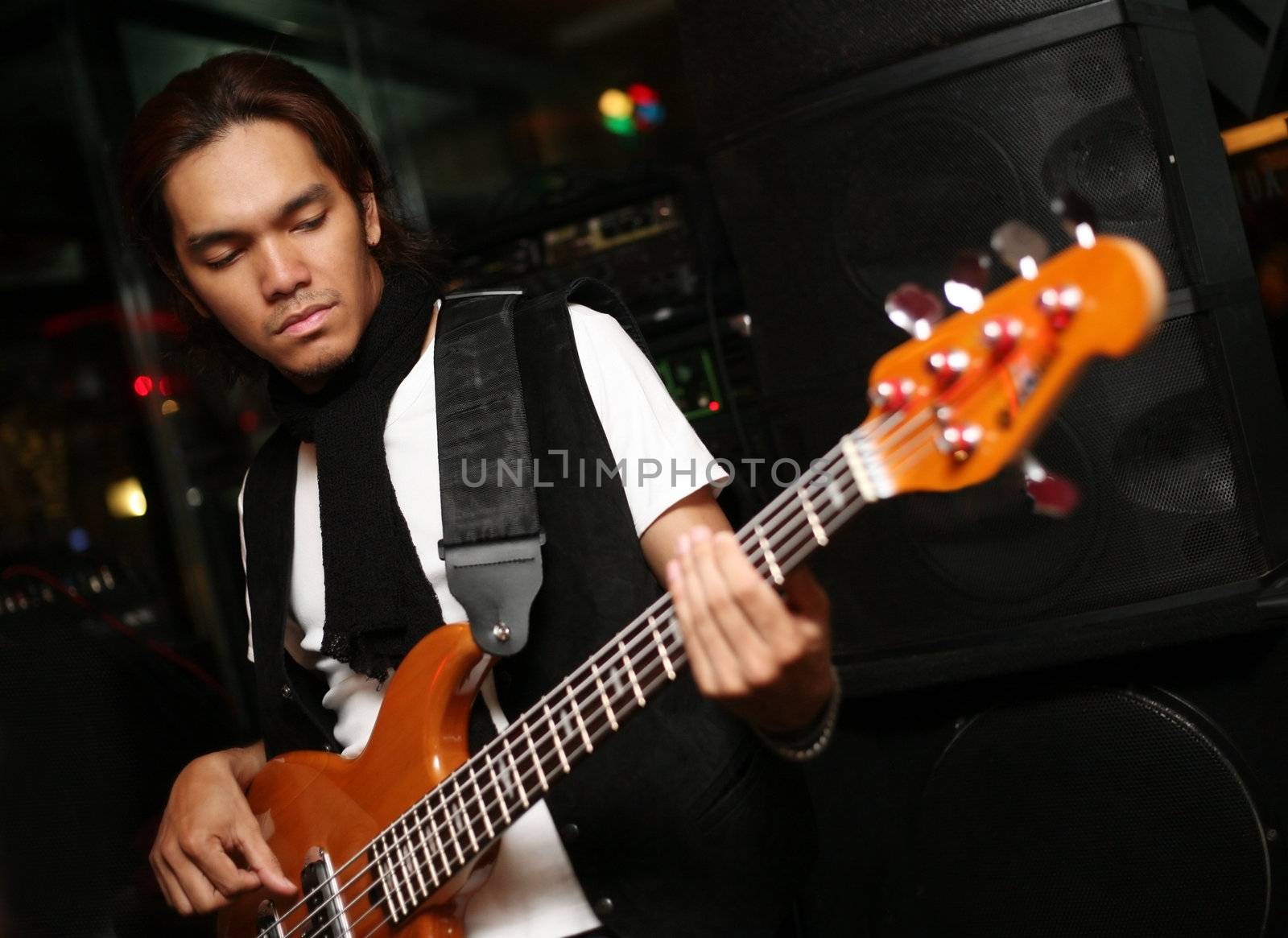 Young musician at an alive concert in a night club "La vida loka". Bali. Indonesia