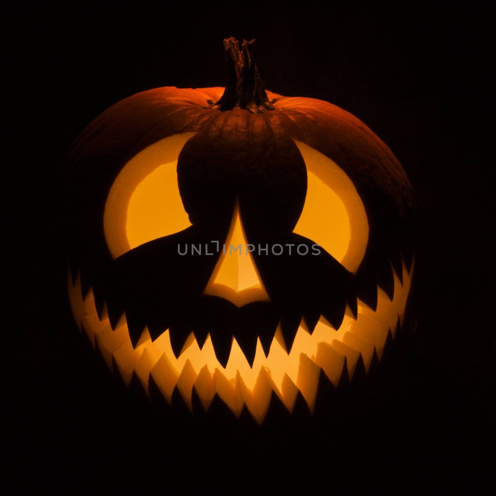 Carved Halloween pumpkin glowing in the dark.