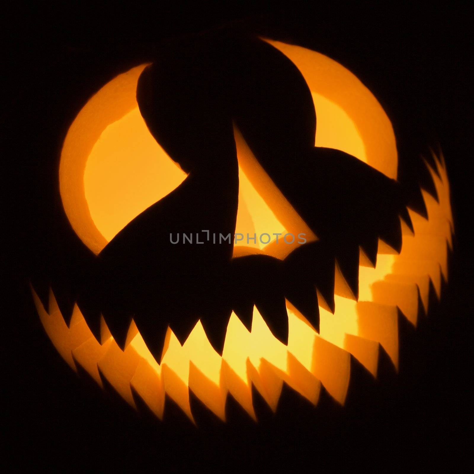 Carved Halloween pumpkin glowing in the dark.