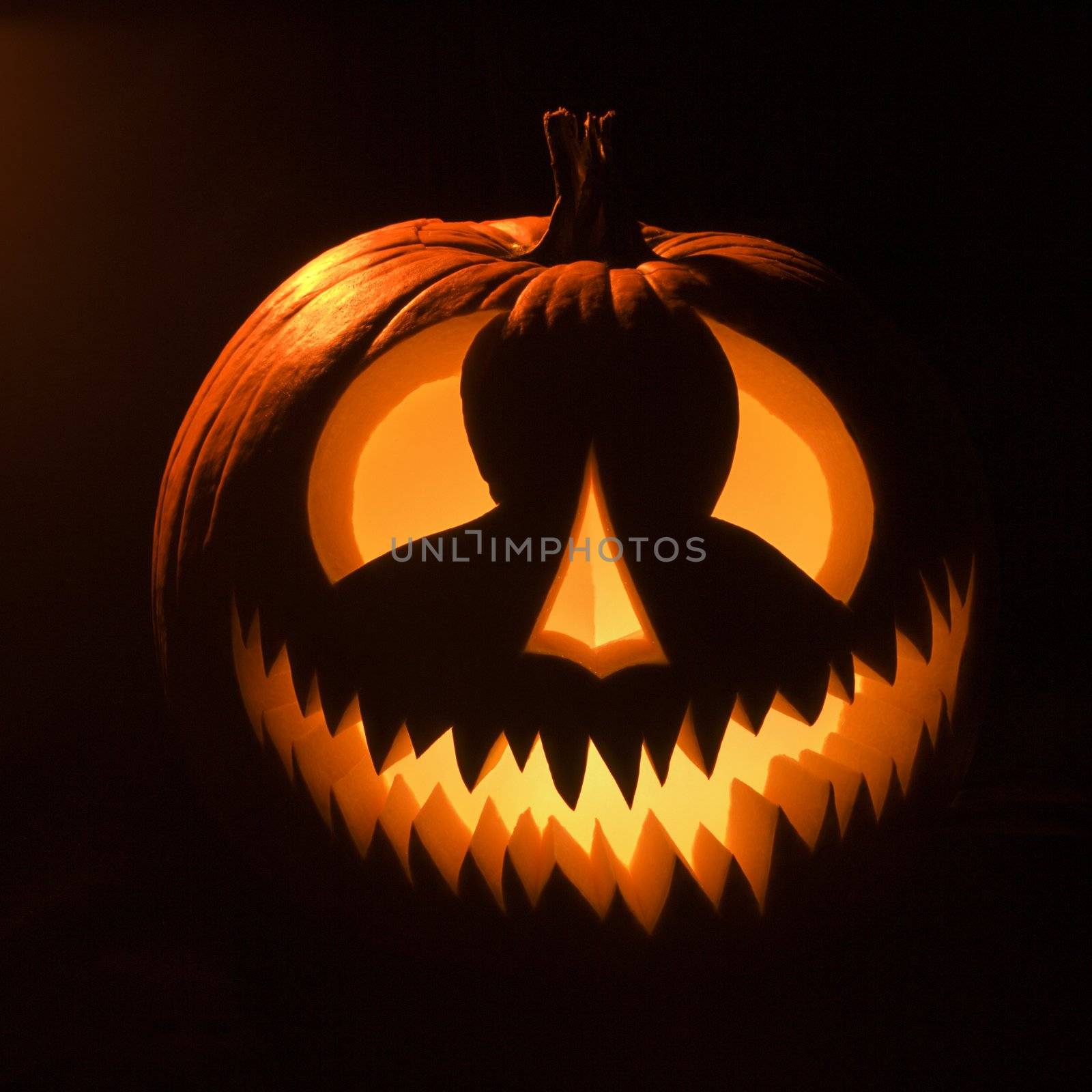 Carved Halloween pumpkin glowing in the dark.