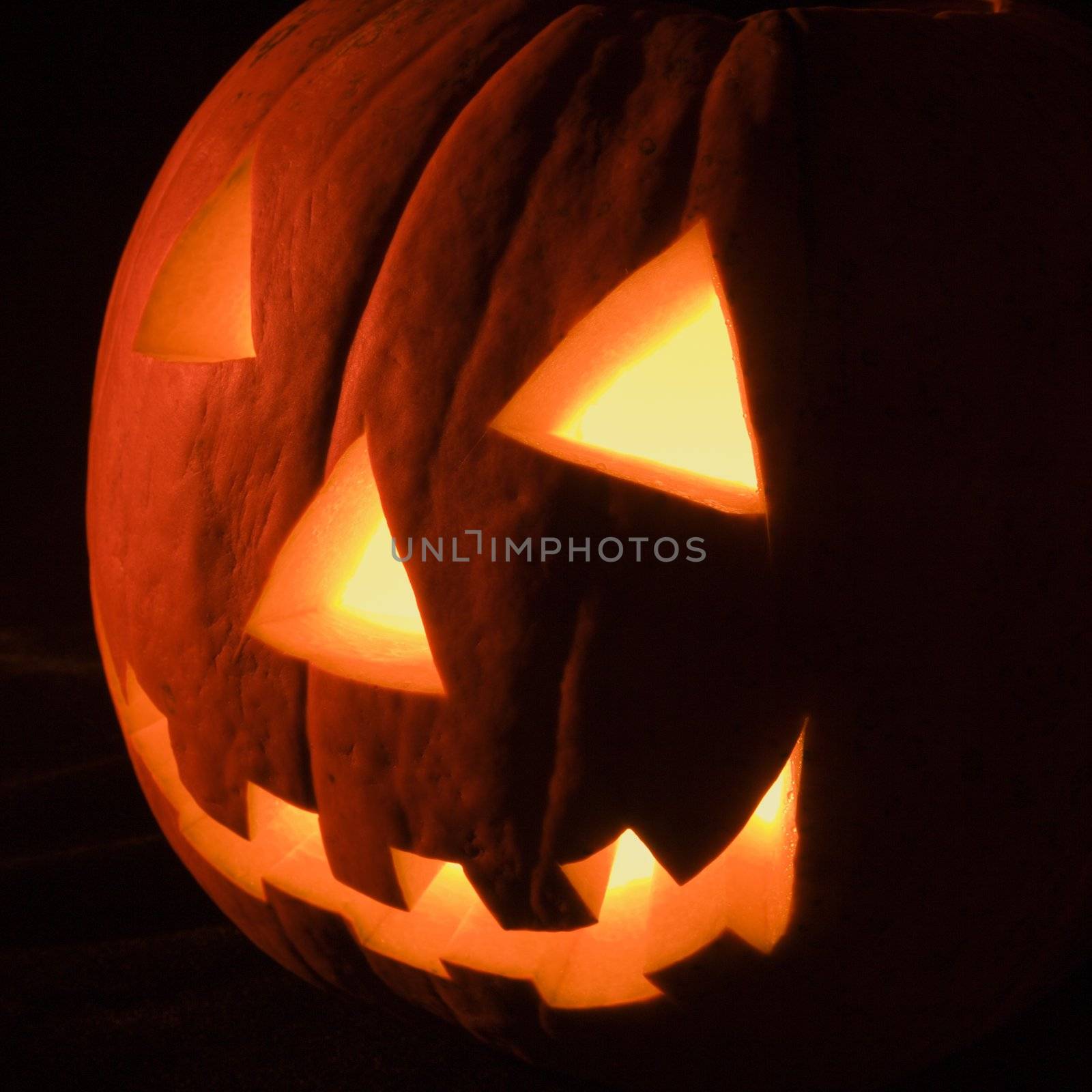 Carved Halloween pumpkin glowing in the dark.