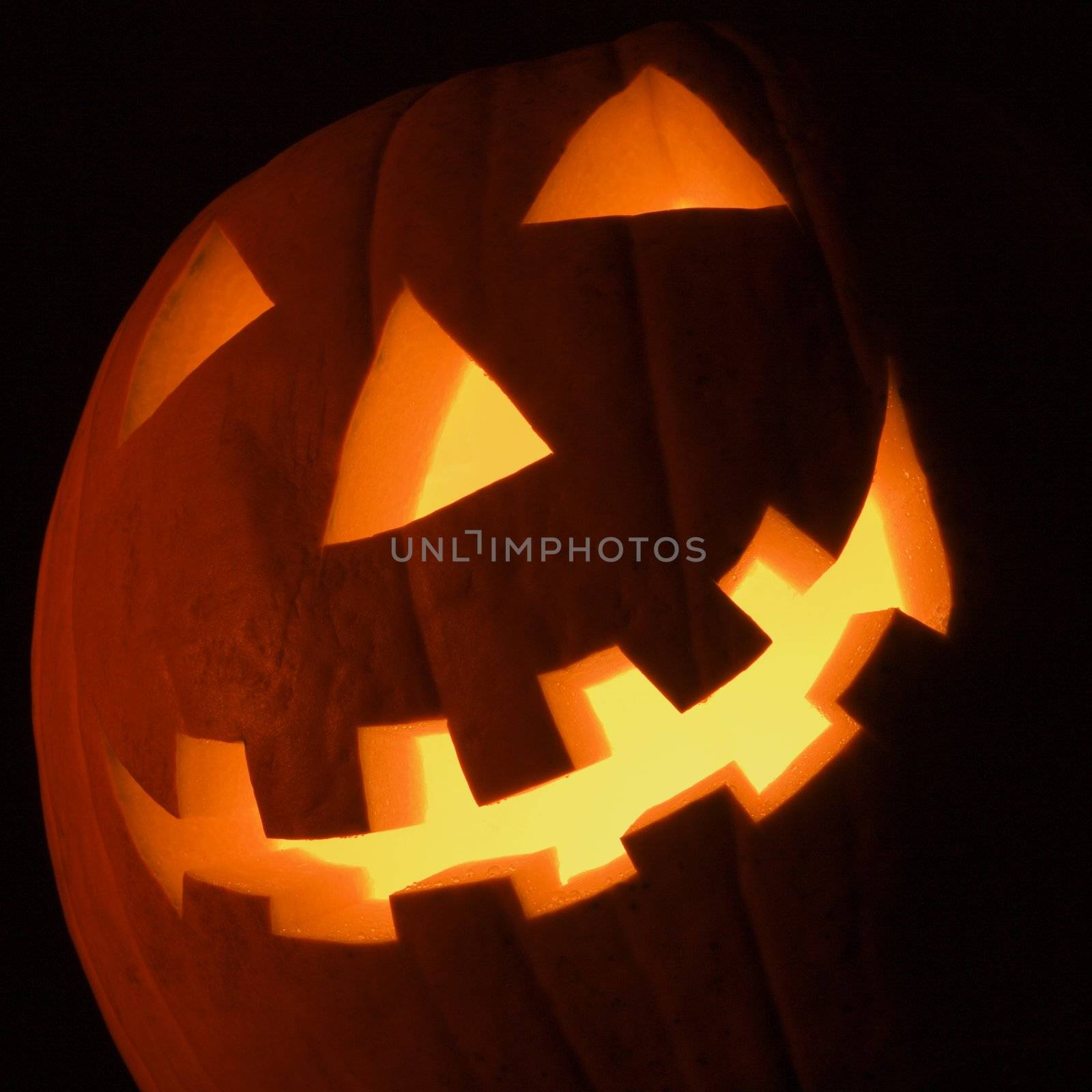 Carved Halloween pumpkin glowing in the dark.