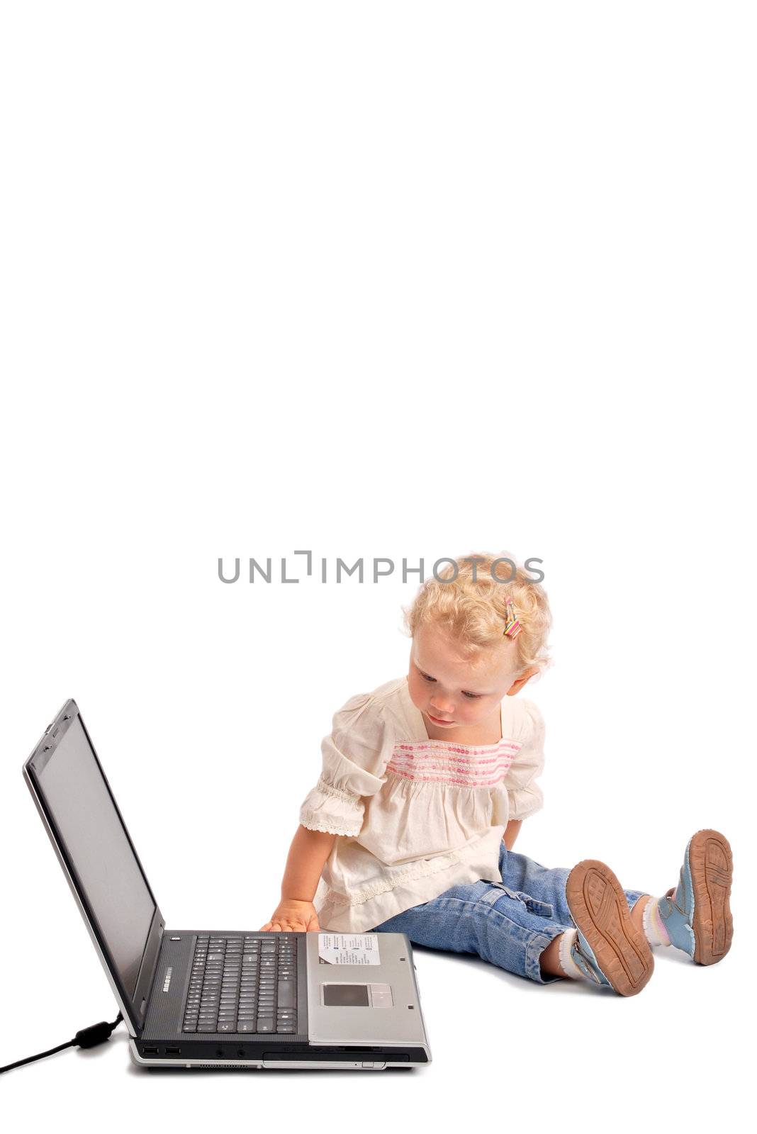 Baby girl looking curiously at a notebook on white background