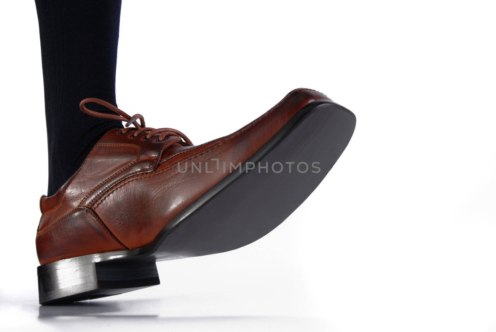 Close-up of male shoe stepping on white background by cienpies