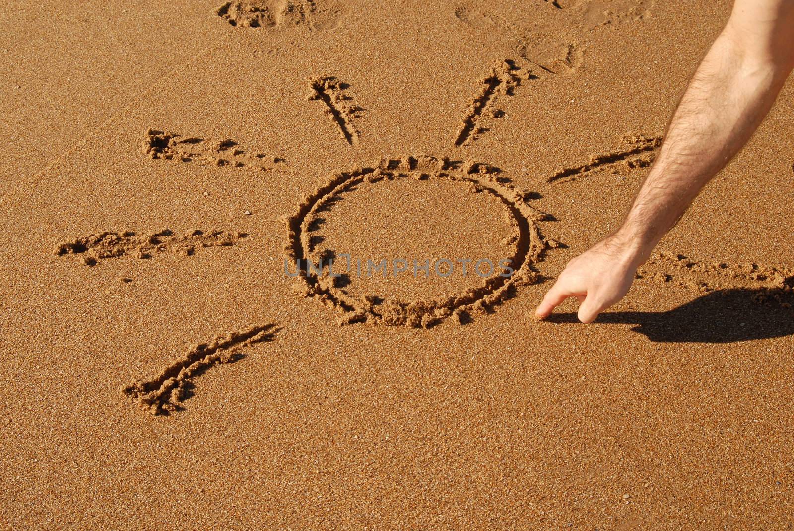 naif sun being drawed in the sand on the beach