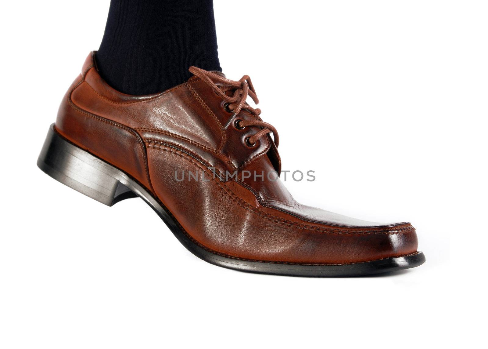 Male foot in brow shoe walking on white background