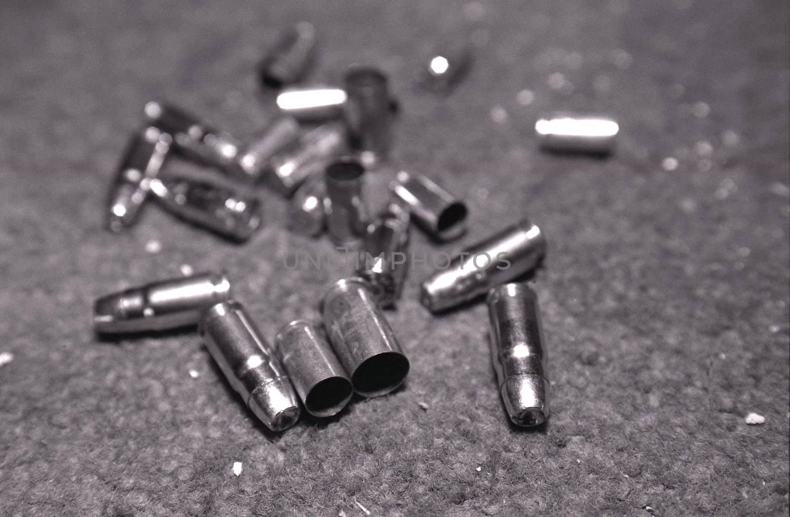 Close up of spent bullets and shells on grey
