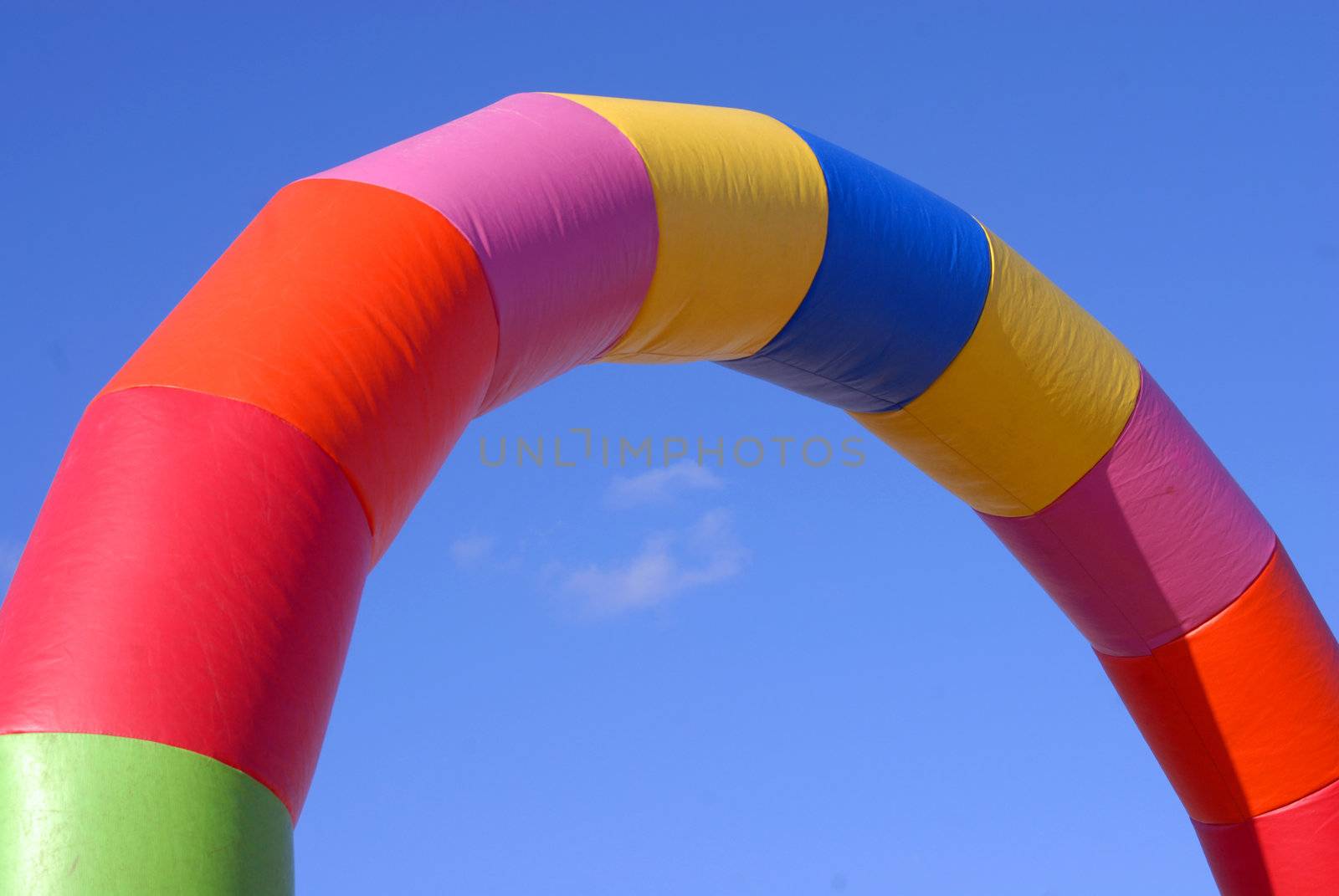 Colorful inflatable arch shaped tube on blue sky background 