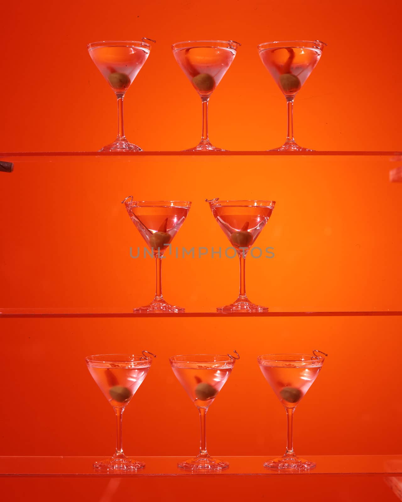 Three shelves with martinis on red
