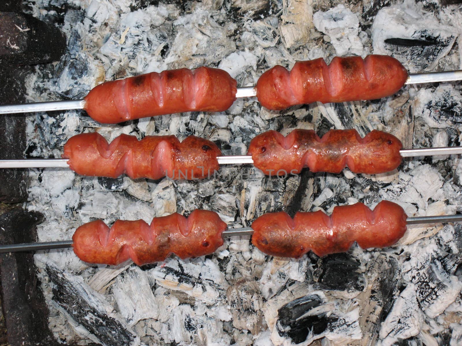 Sausages above hot embers by Vitamin