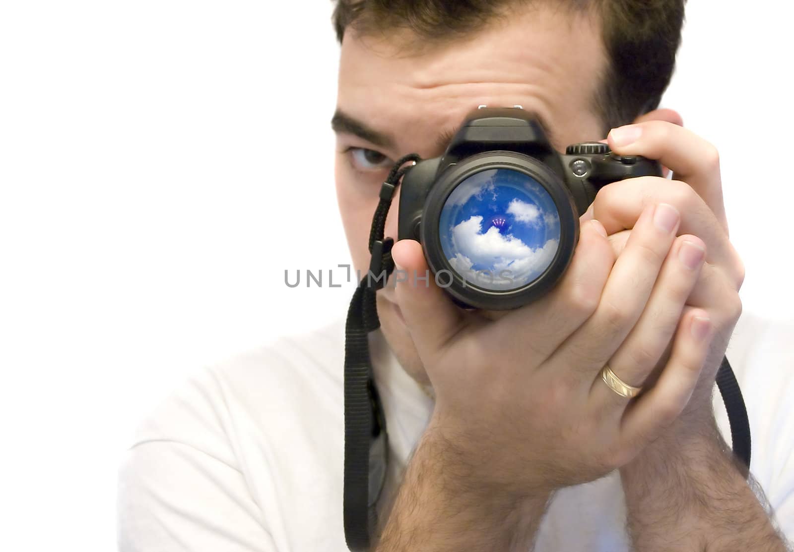 A young photographer taking a shot of some clouds with his DSLR camera.