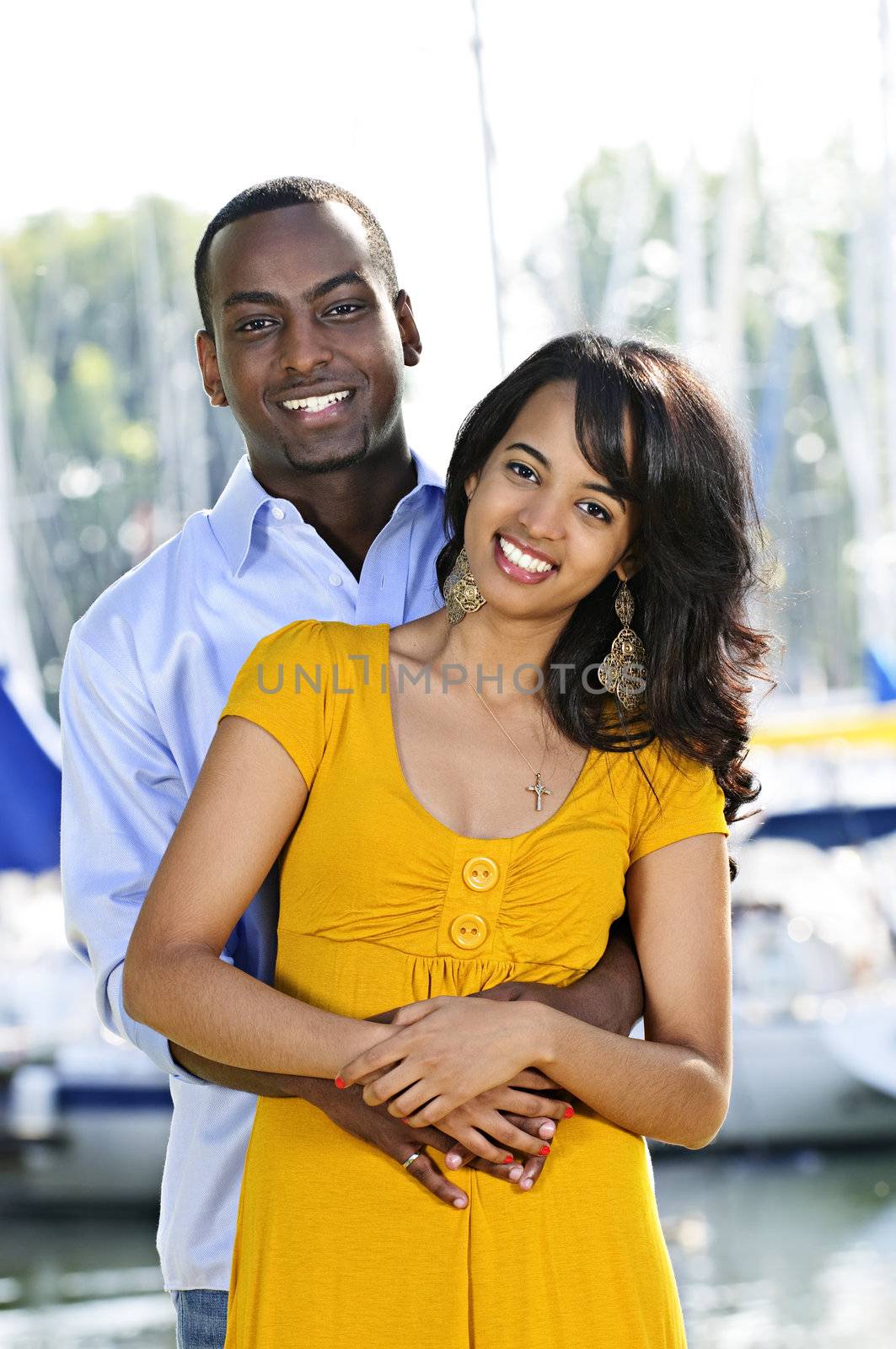 Young romantic couple hugging and standing at harbor