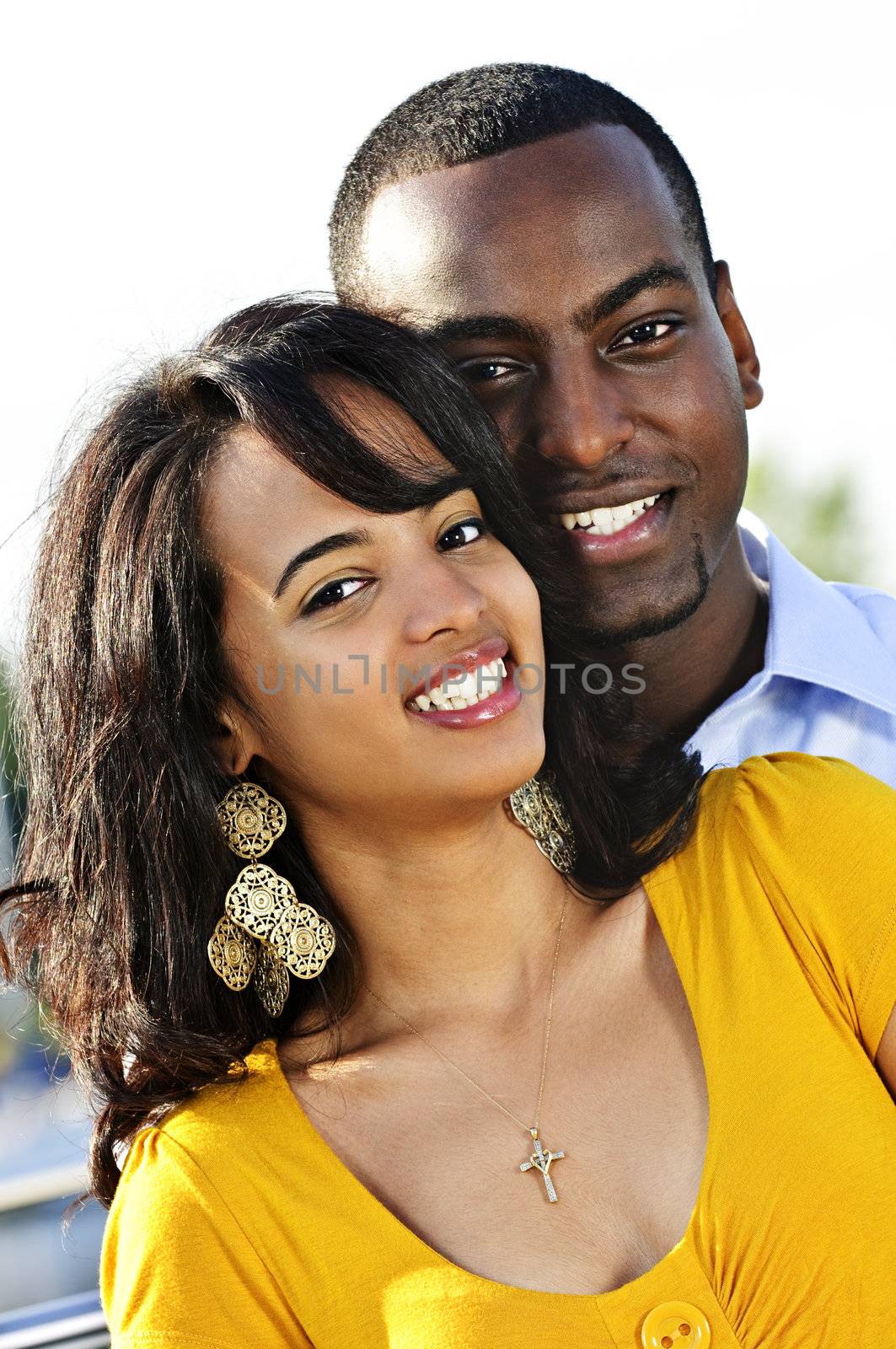 Portrait of young romantic couple standing at harbor