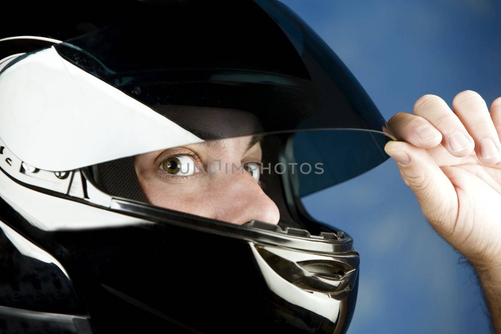 Close-up of a wide-eyed man wearing a motorcycle helmet