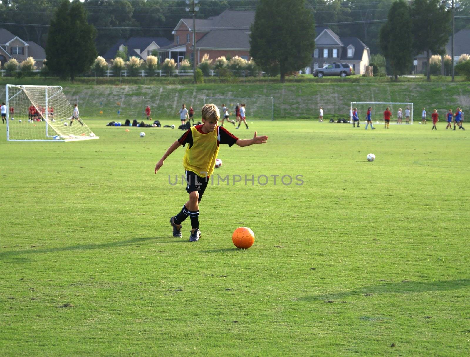 Boy kicking a soccer ball on the field.                 