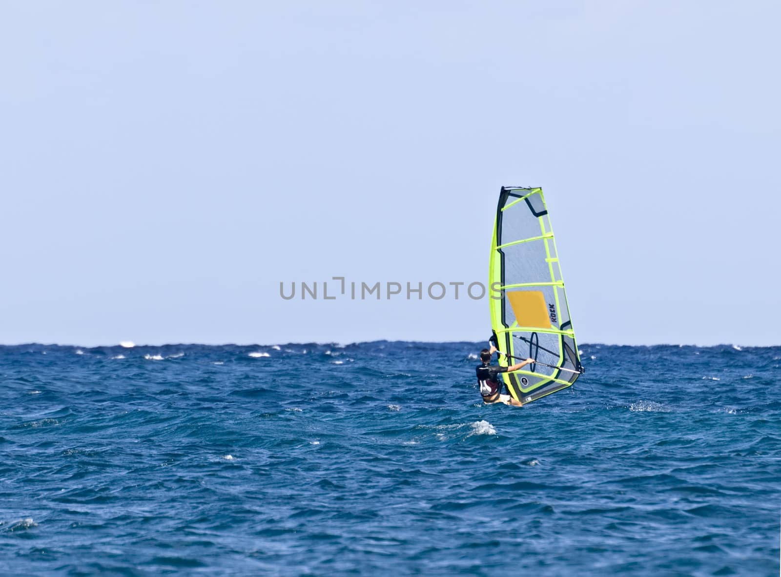 A lone surfer riding the wind in the Mediterranean