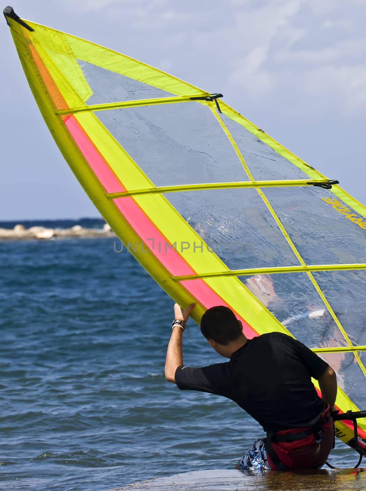 A windsurfer getting prepared to hit the waves in Malta