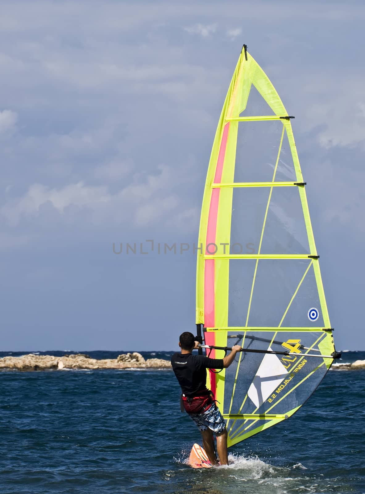 Windsirfer skimming along the waves in the Mediterranean Sea