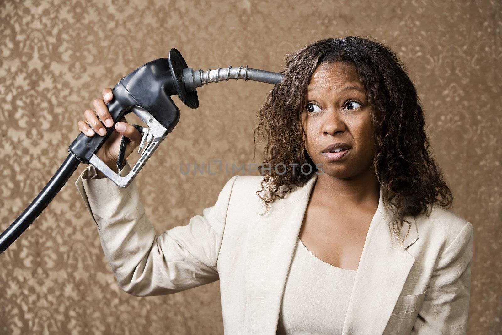 Woman holding gas nozzle like a gun to her head