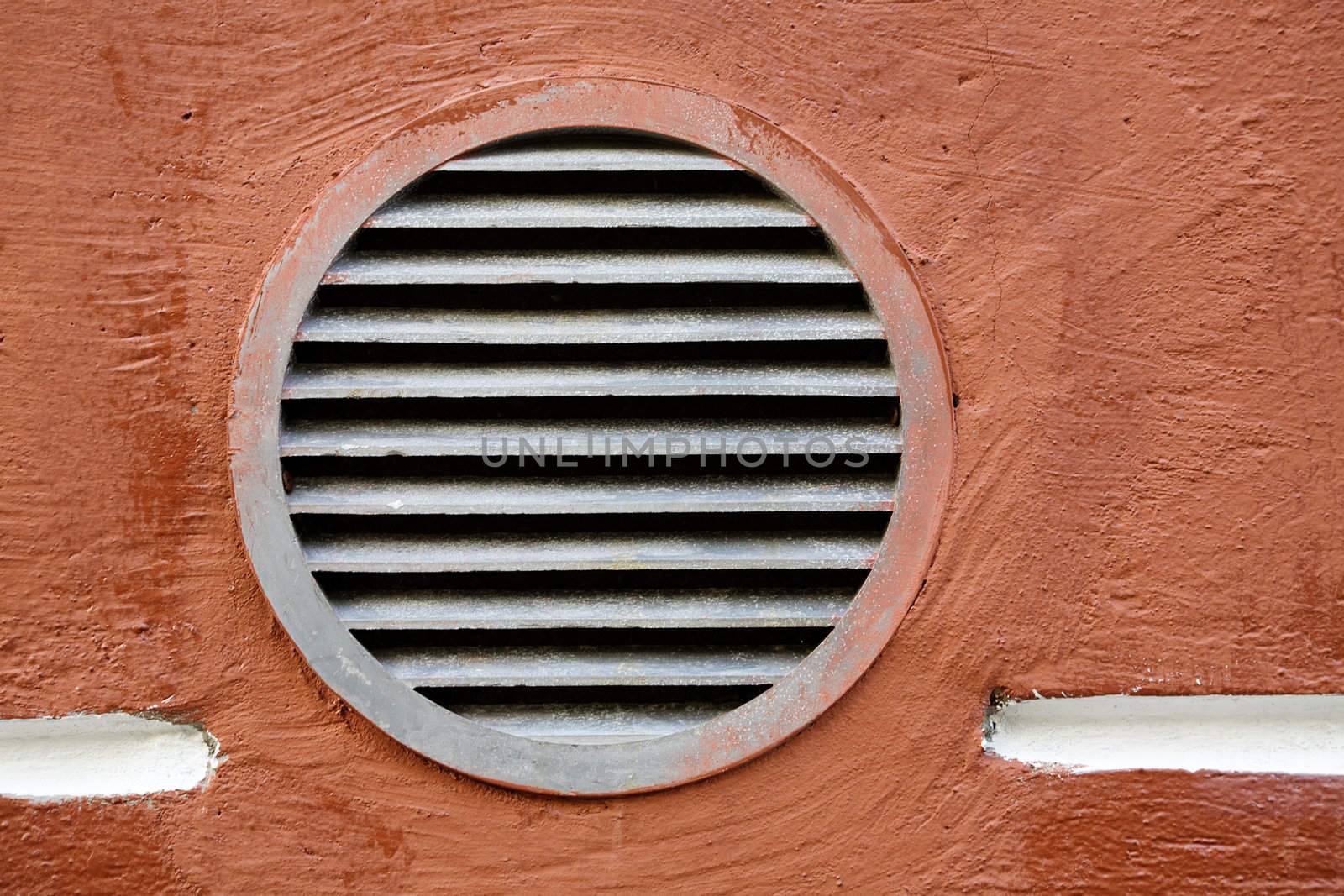 Rusty round lattice on a red wall