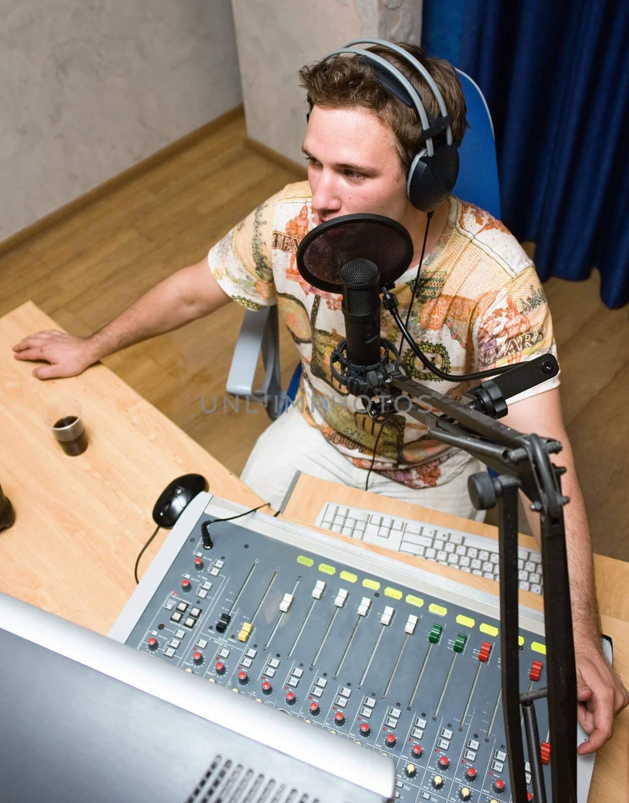 Radio DJ.  Young man with microphone and big headphone.