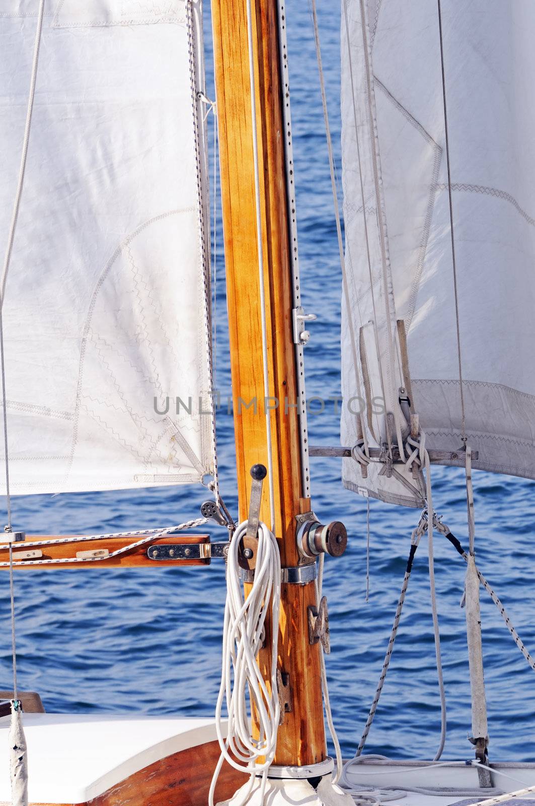 Detail of a wooden mast and sail of a boat navigating