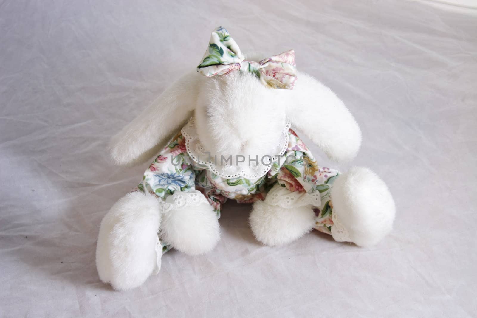 small white bunny rabbit toy dressed in a florel suit with a bow on its head