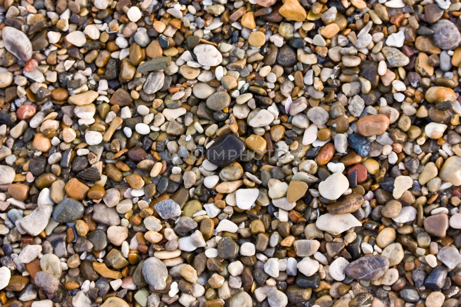 Colorful pebbles on a beach - background texture
