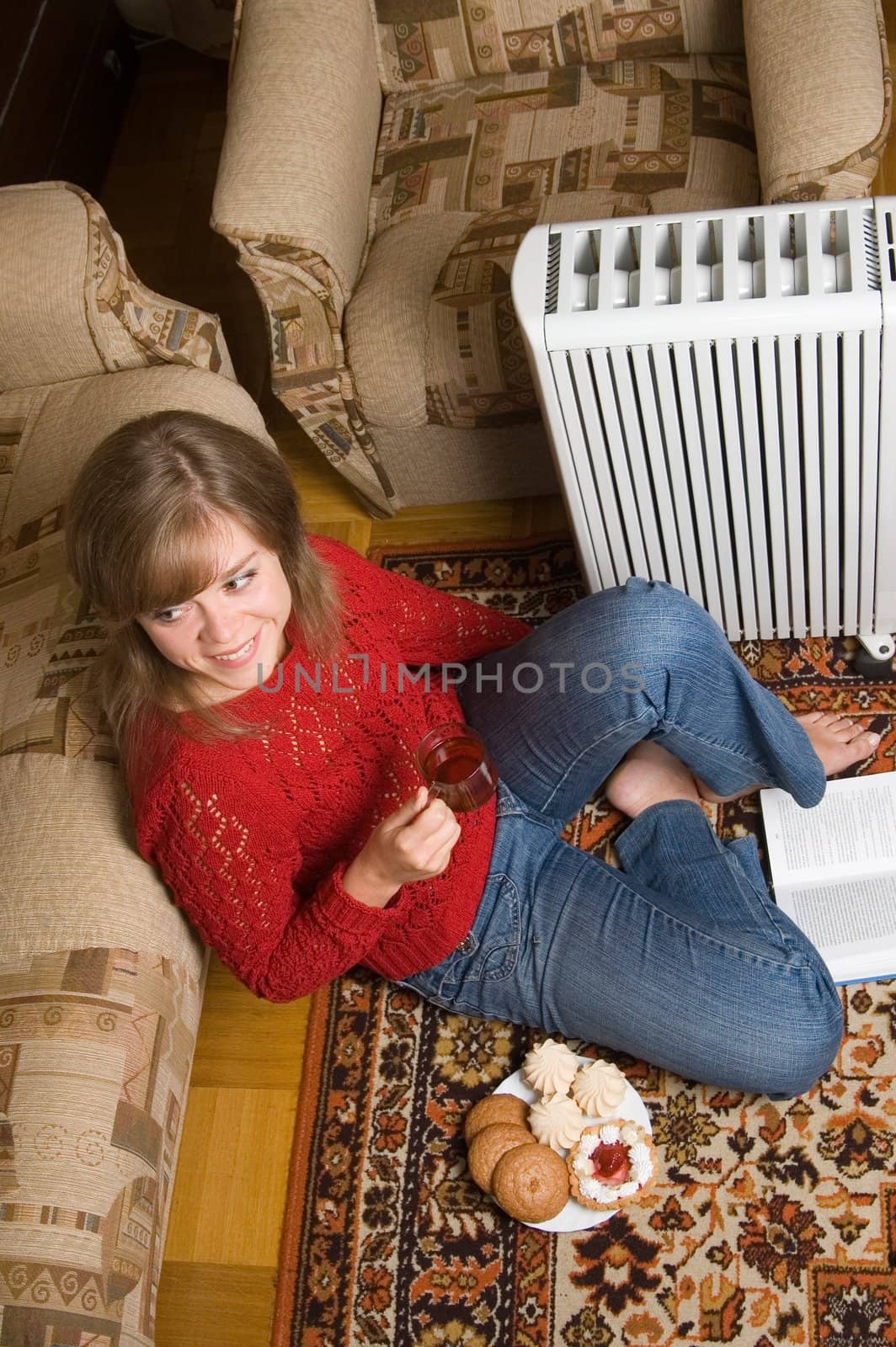 Woman sits on a carpet in a living room