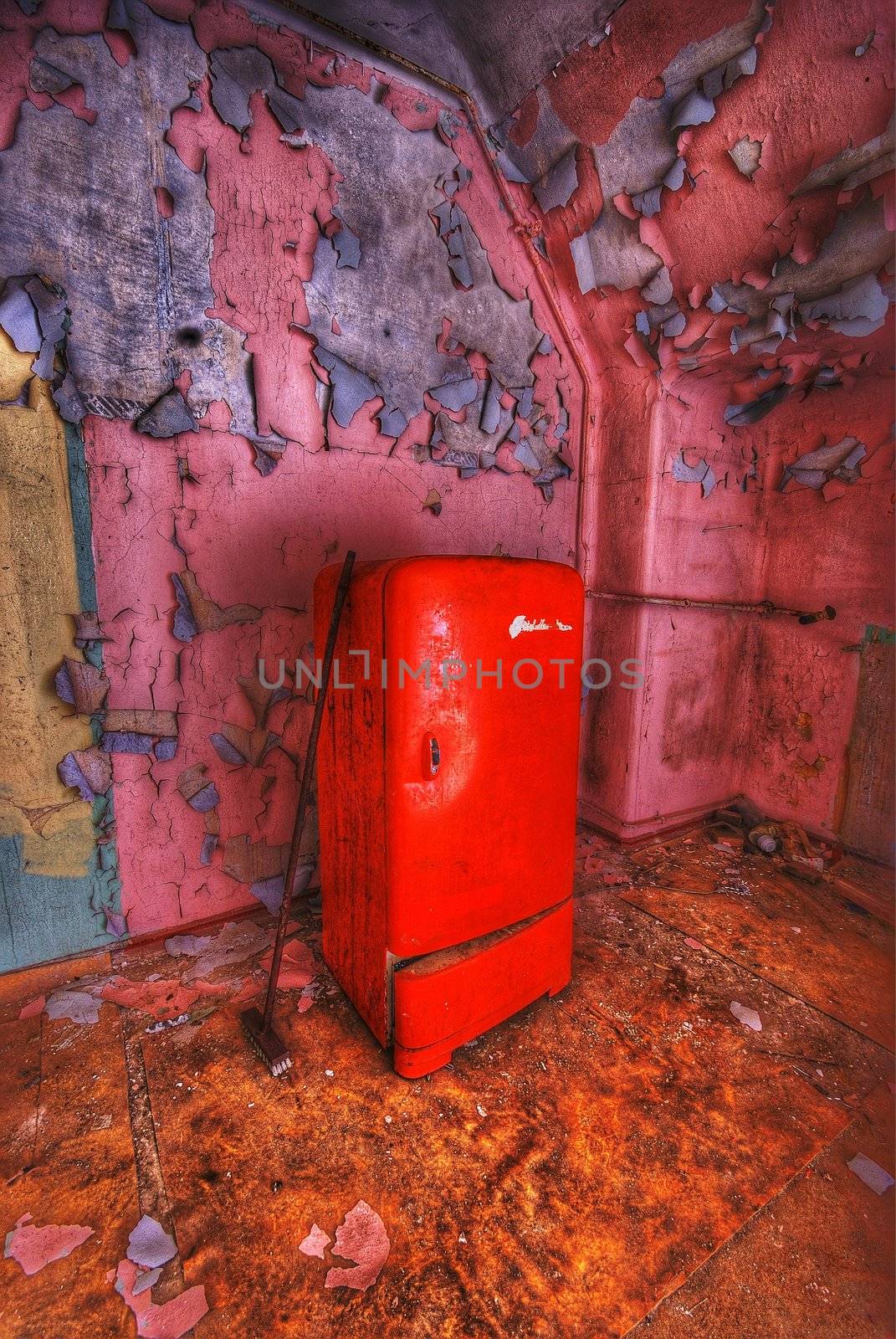 old fridge and a mop in an abandoned building