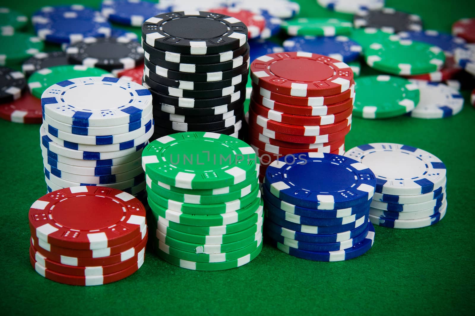 Lot of poker chips on green background.