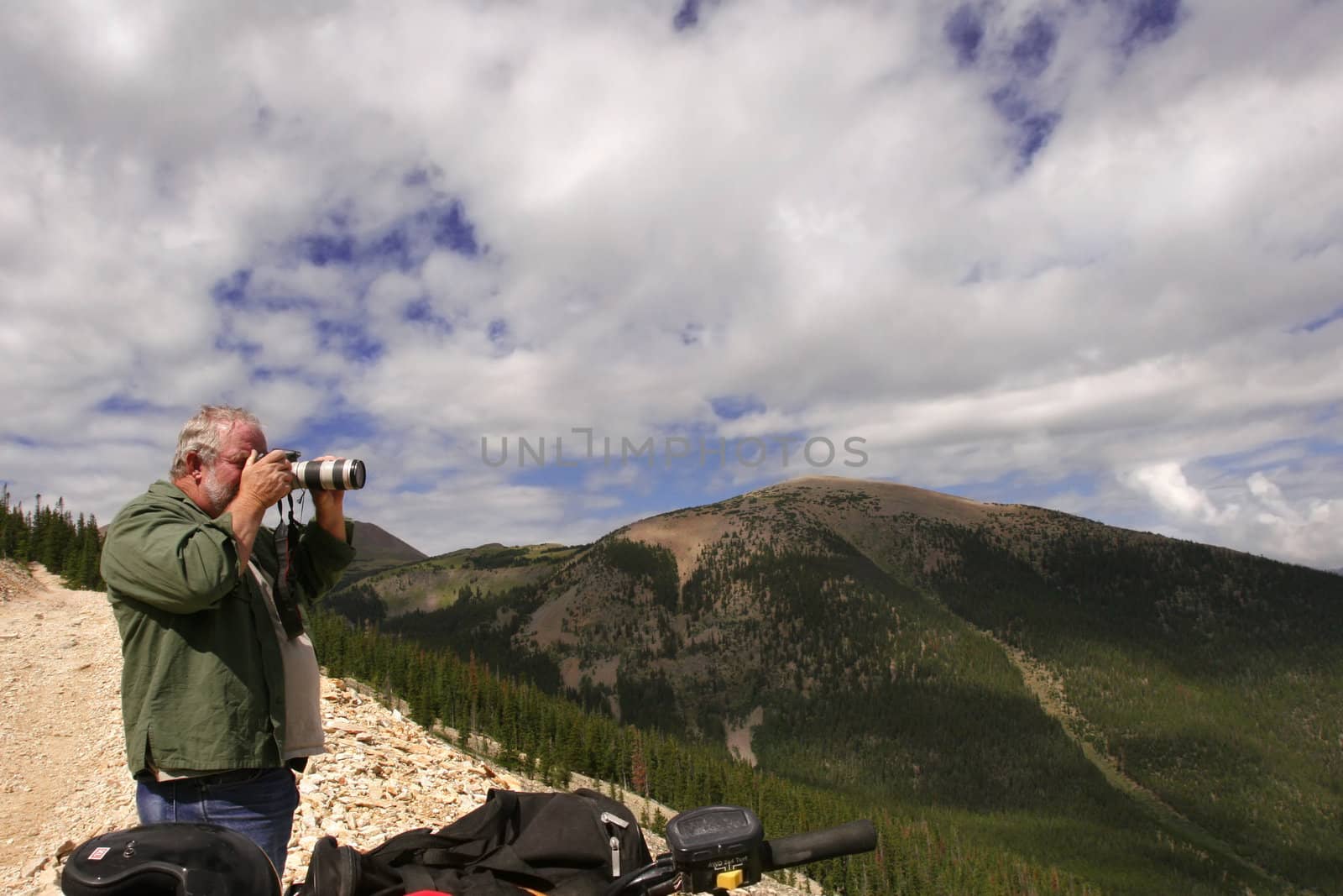 Senior photographer taking photographs in the mountains