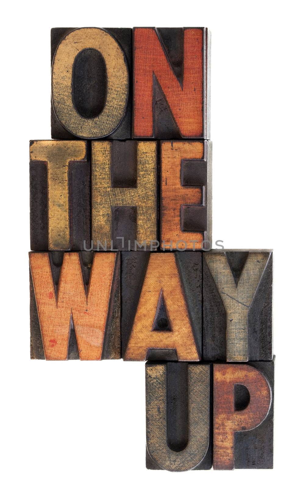 On the way up phrase in vintage letterpress wooden type, stained by ink, vertical layout, isolated on white